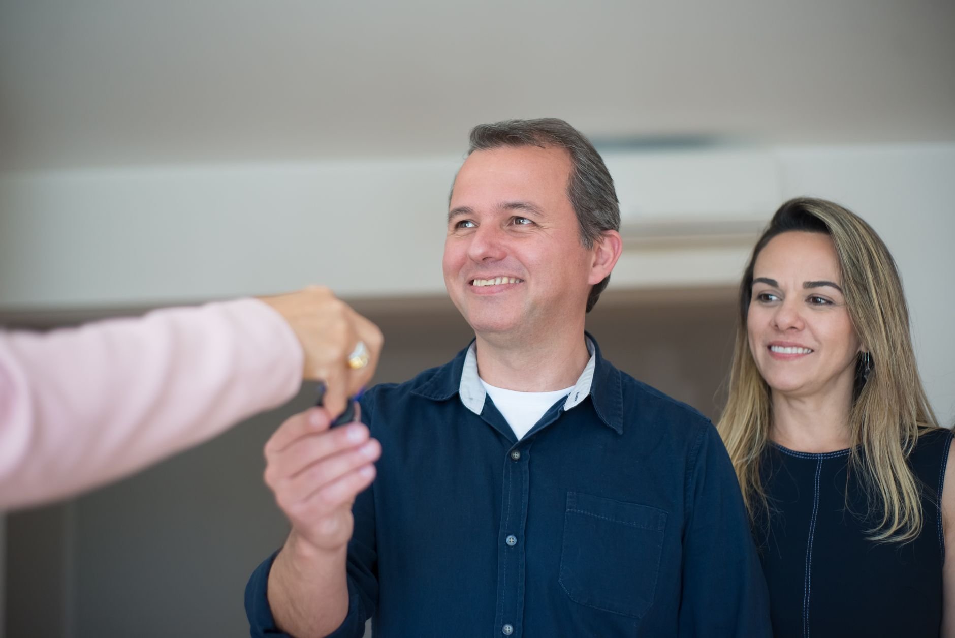 A couple receiving keys, smiling — the moment Apex delivers